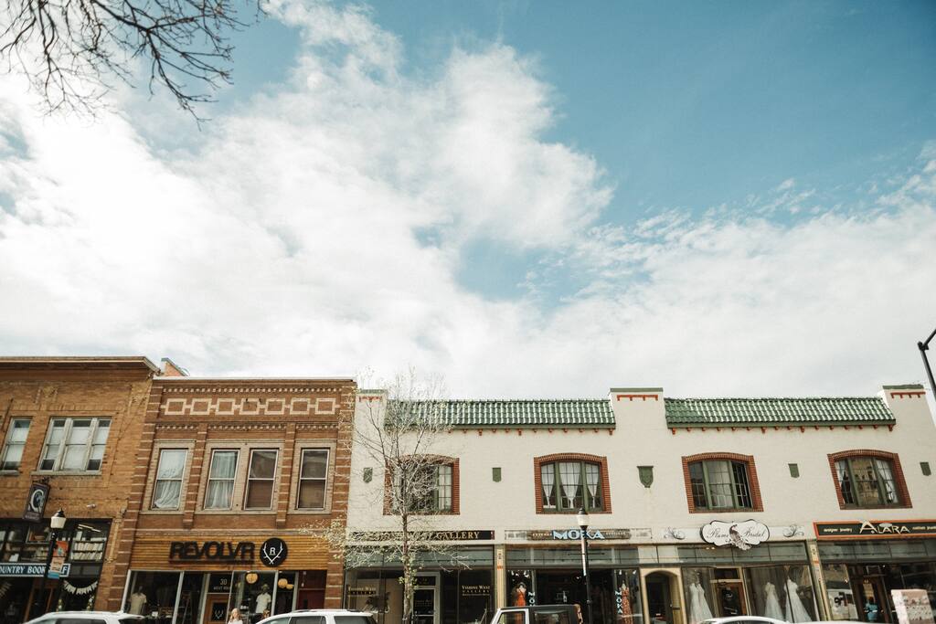 Historic storefronts in downtown Bozeman under a bright blue sky